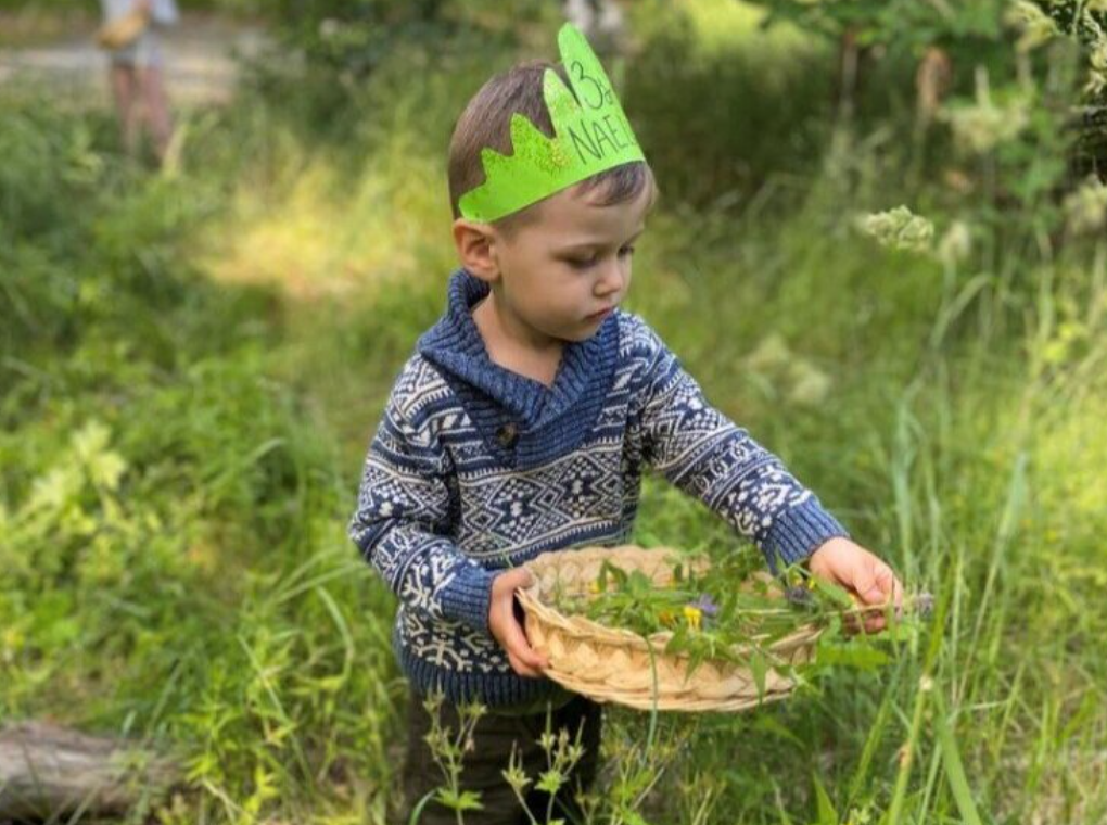 barn som håller i en korg med blommor